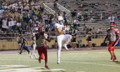 man catching brown football on stadium