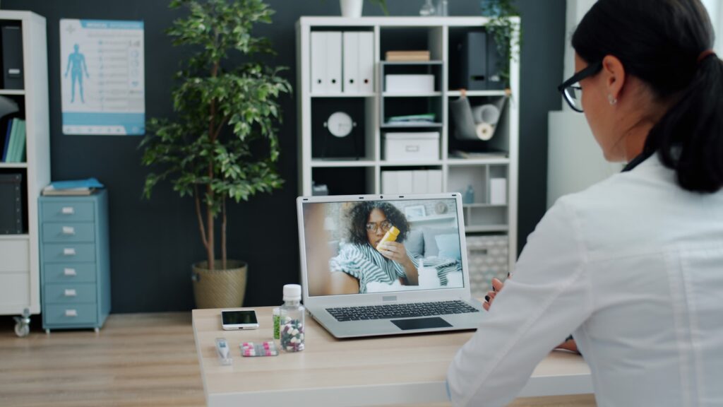 Discover Healthcare Made Simple with Vezeeta 17 Doctor consulting patient via video call on laptop.