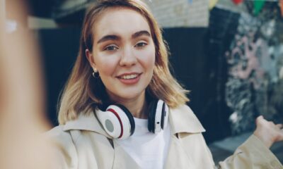 Young woman with headphones talking outdoors