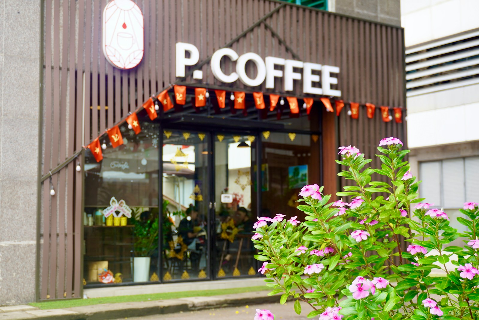 a coffee shop with flowers in front of it