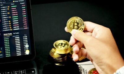 gold round coin on persons hand