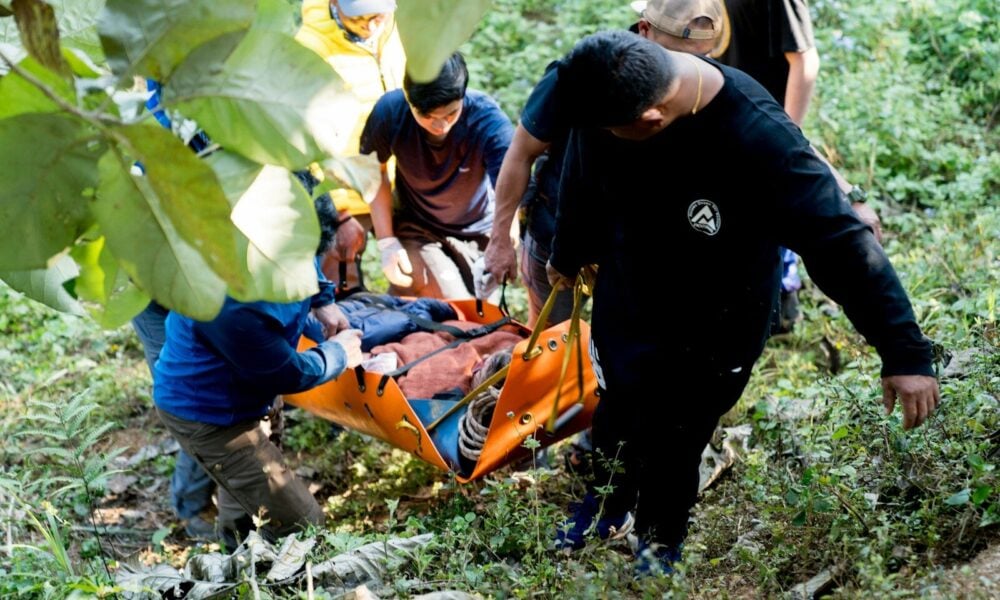 A group of people standing around a man on a stretcher