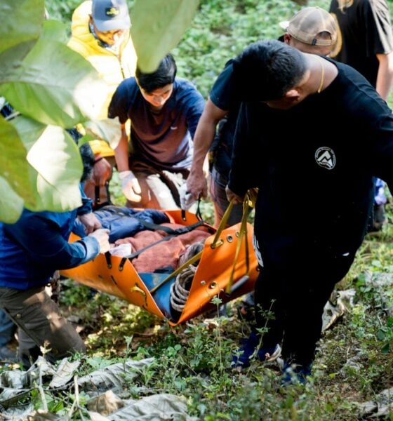 A group of people standing around a man on a stretcher