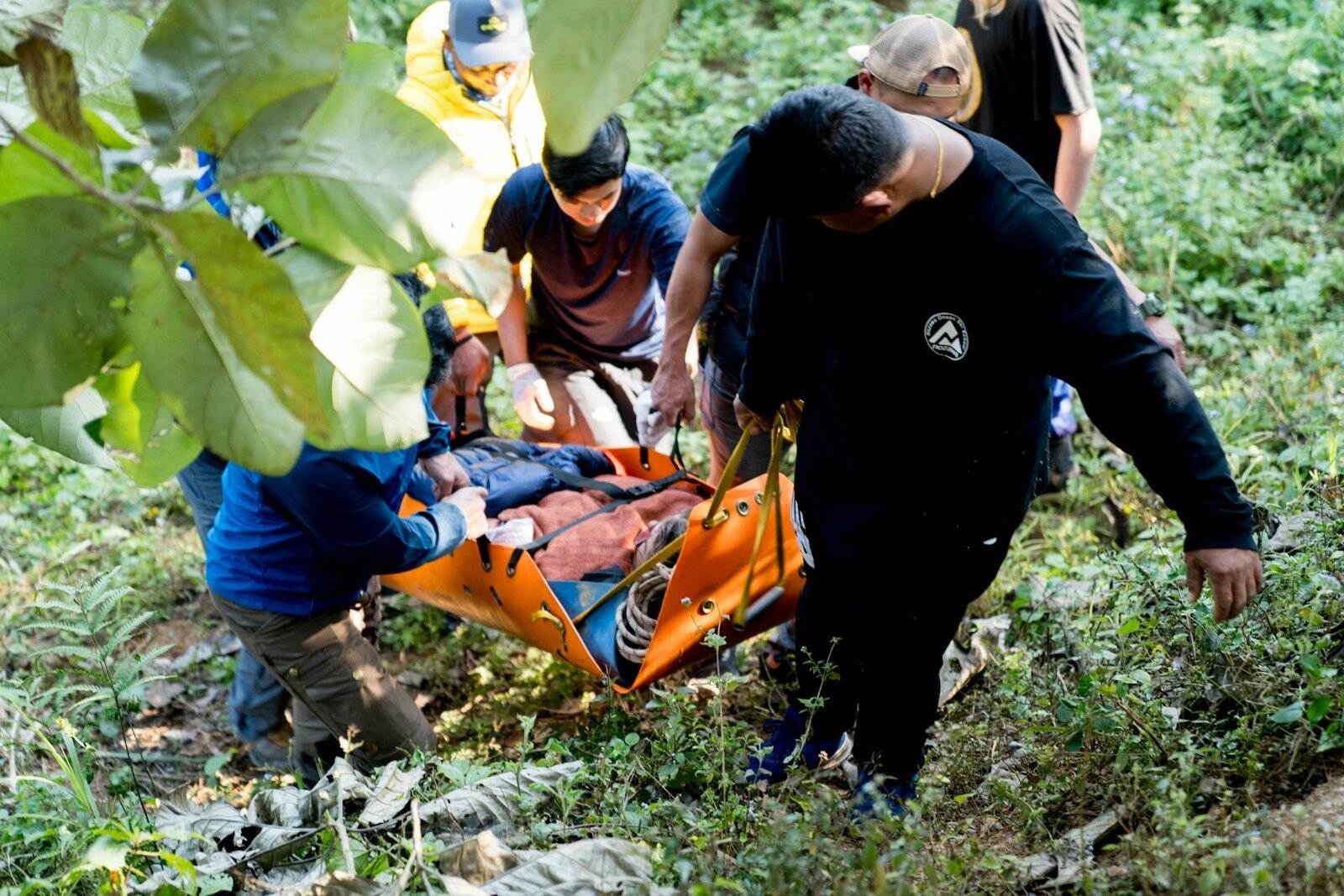 A group of people standing around a man on a stretcher