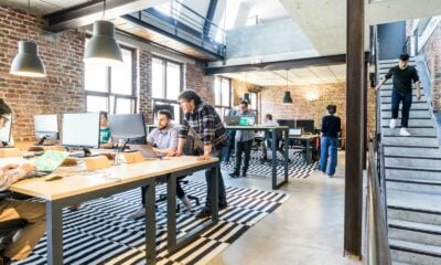 man standing beside another sitting man using computer. Startup Bootstrapped Fundraising Strategy