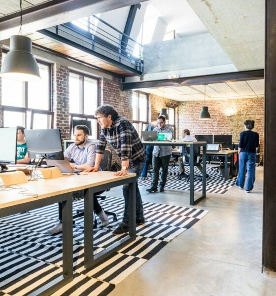 man standing beside another sitting man using computer. Startup Bootstrapped Fundraising Strategy
