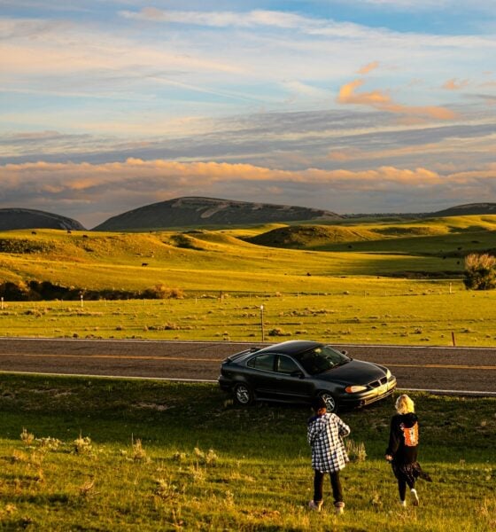 a couple of people standing next to a car