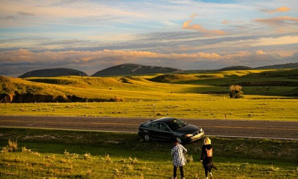 a couple of people standing next to a car