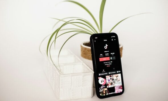 a cell phone sitting on top of a table next to a plant