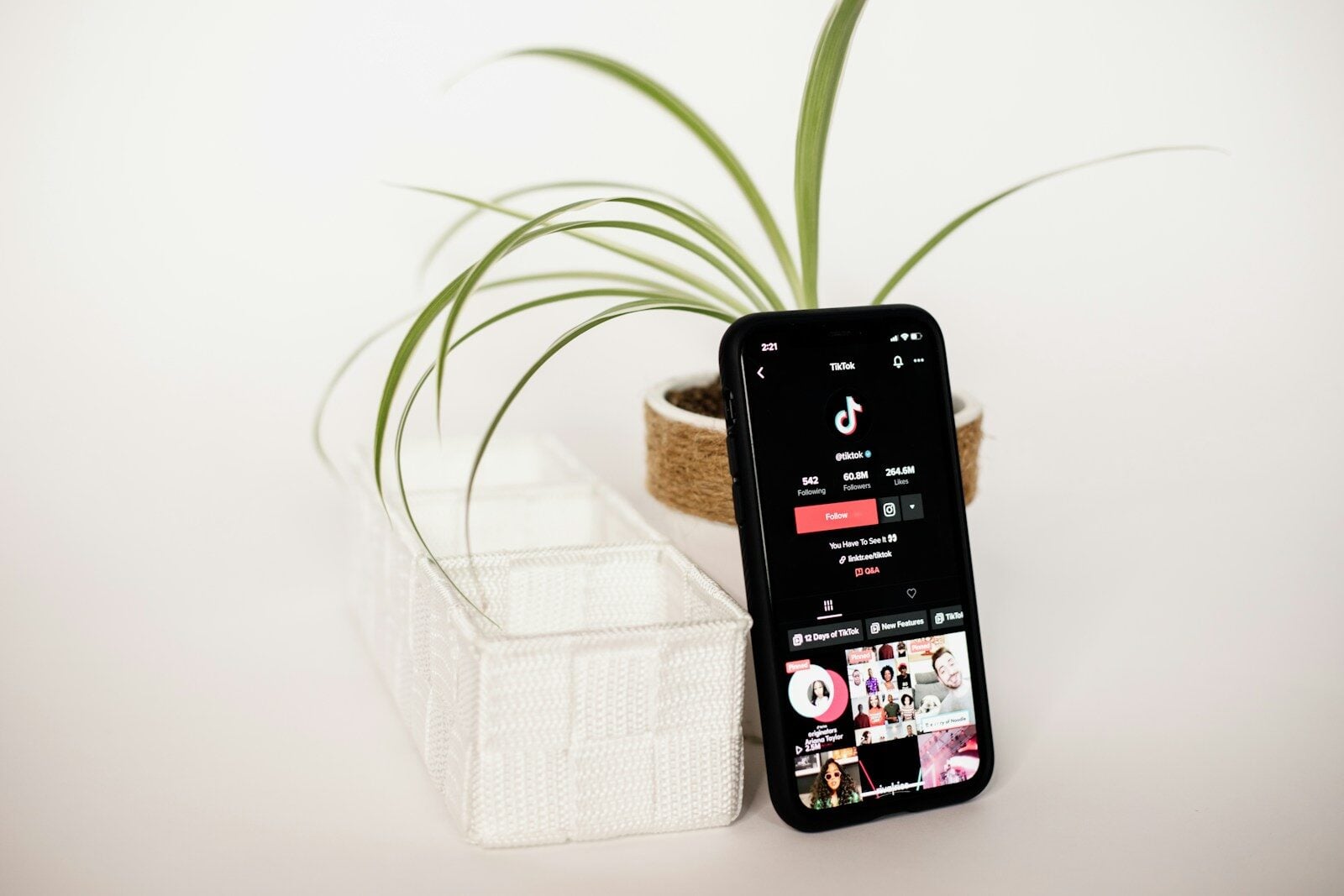 a cell phone sitting on top of a table next to a plant