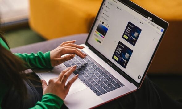 a woman sitting on a couch using a laptop computer