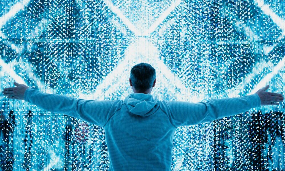 A man standing in front of a large display of numbers