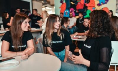 a group of people sitting around a table talking
