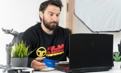 a man sitting at a desk with a laptop and a microphone