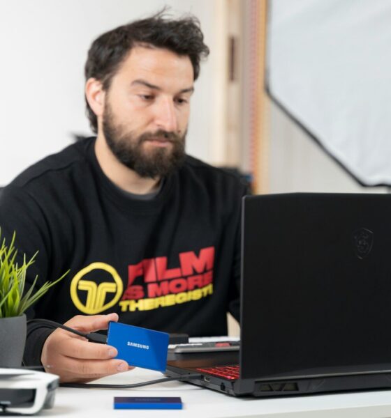 a man sitting at a desk with a laptop and a microphone