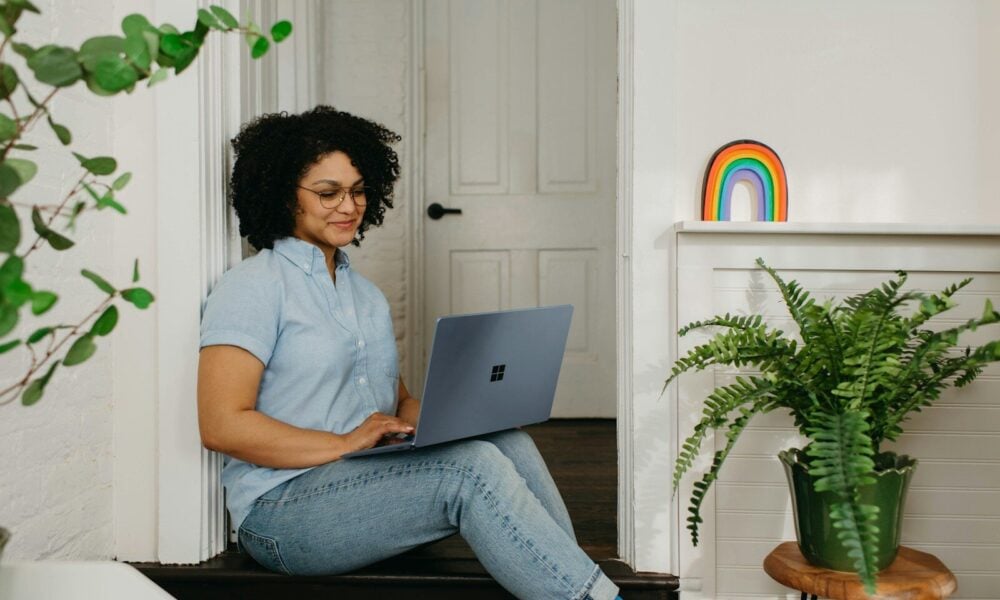 a woman sitting on the floor using a laptop