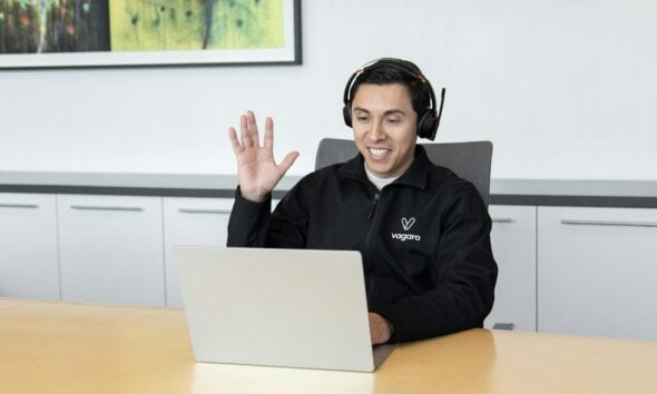 a man wearing headphones sitting in front of a laptop computer