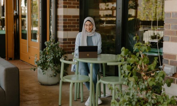 a person sitting at a table with a laptop