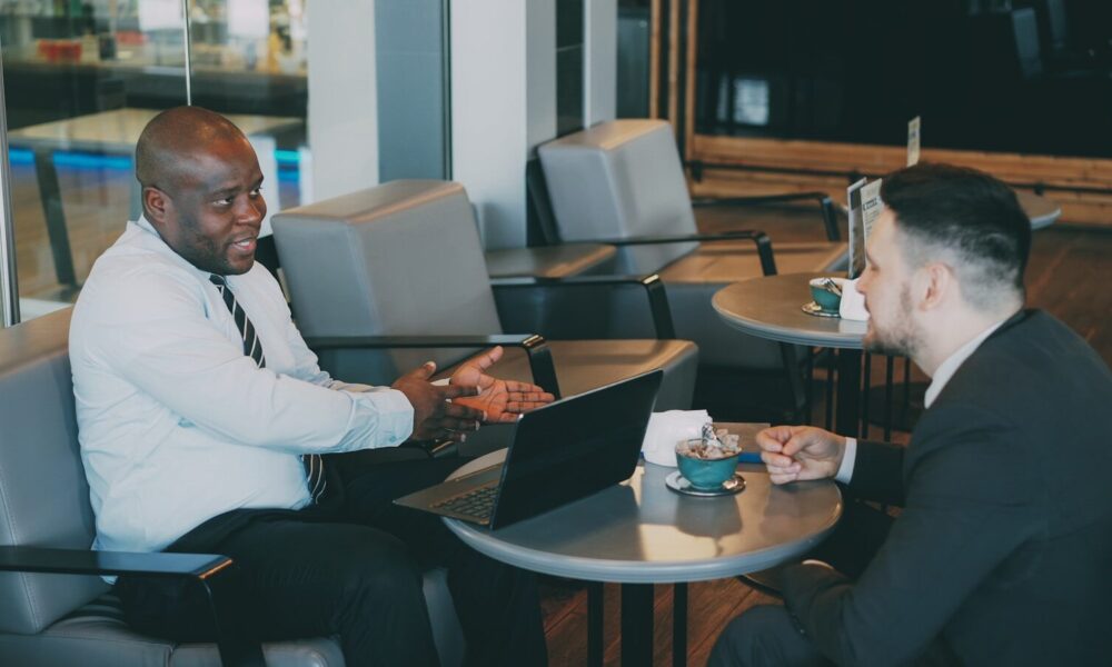 Two businessmen talking at a cafe table