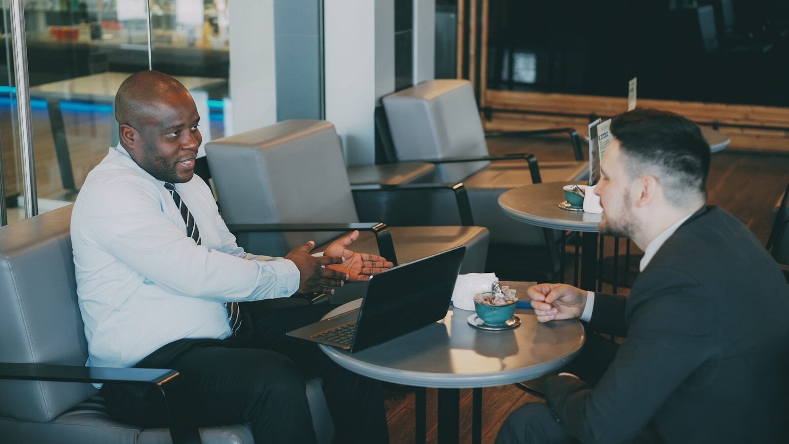 Two businessmen talking at a cafe table