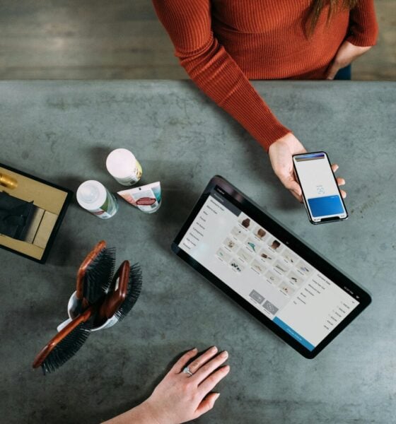 person holding smartphone beside tablet computer