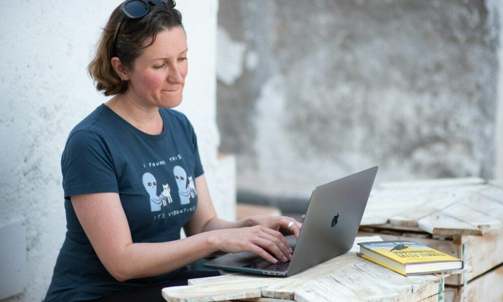 woman in blue crew neck t-shirt using macbook