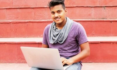 woman in purple shirt and blue denim jeans sitting on concrete bench