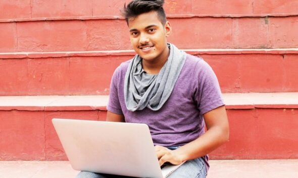 woman in purple shirt and blue denim jeans sitting on concrete bench