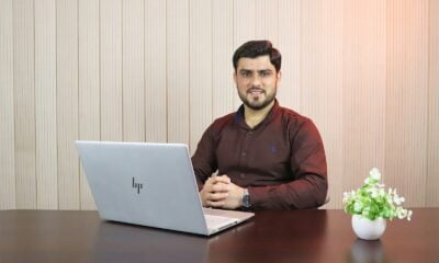 man in red sweater using macbook