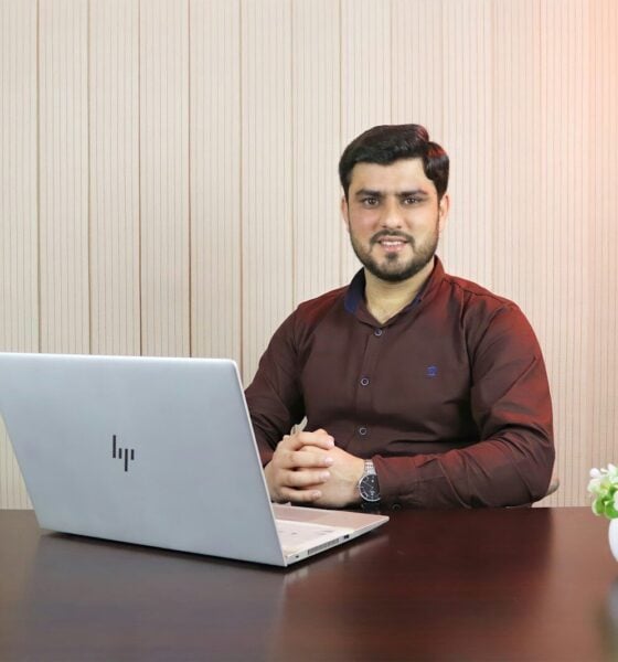 man in red sweater using macbook