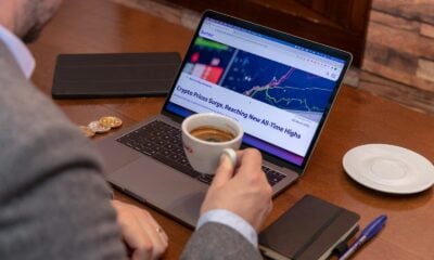 a man sitting at a table with a laptop and a cup of coffee