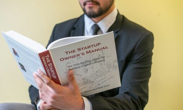 a man in a suit is reading a book