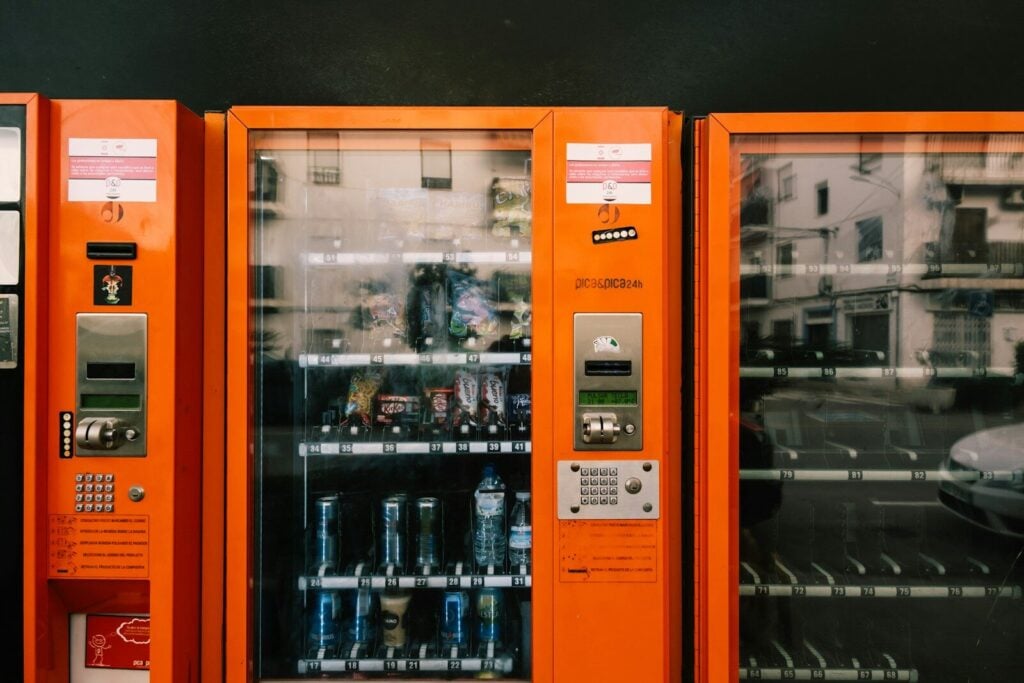 an orange vending machine with sodas in it