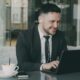 Man in suit working on laptop in cafe