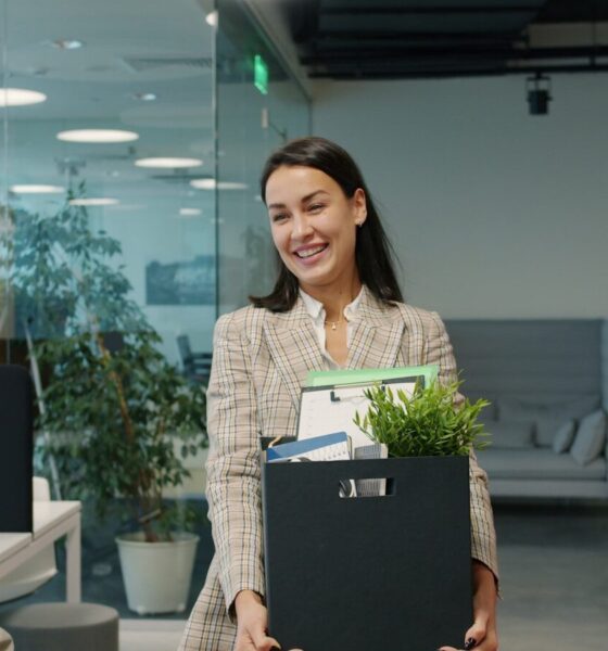Woman carrying box of belongings leaving office