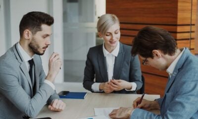 Business people signing a contract at a table.