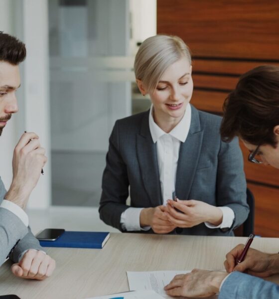 Business people signing a contract at a table.