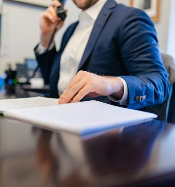 a man sitting at a desk writing on a piece of paper