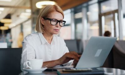 a woman sitting at a table using a laptop computer