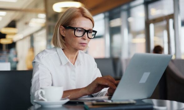 a woman sitting at a table using a laptop computer