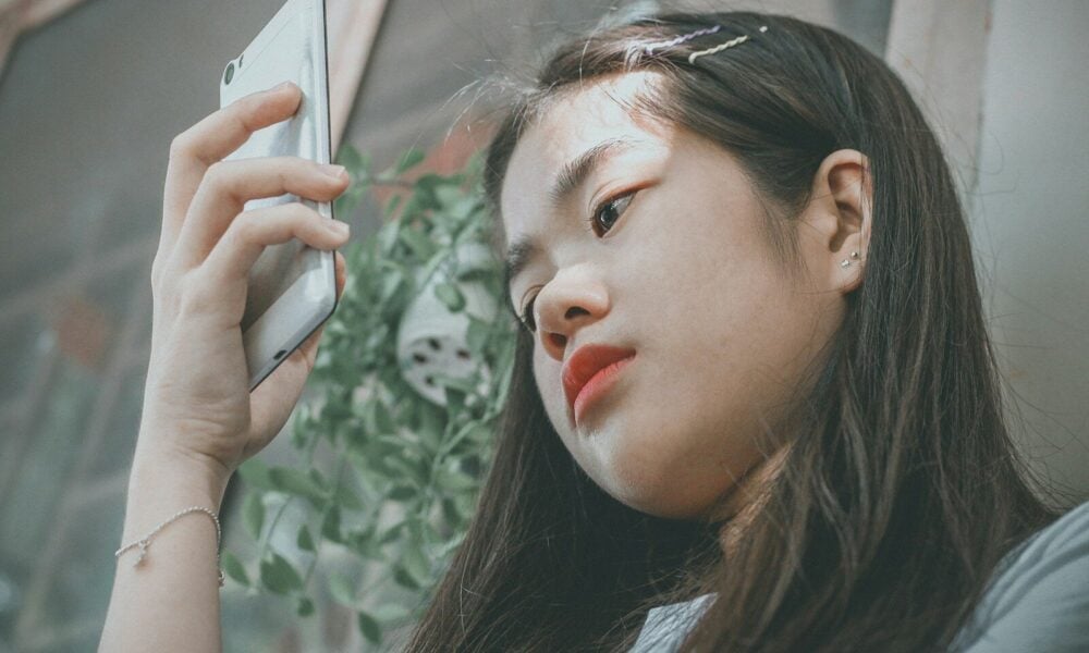 woman holding smartphone outside
