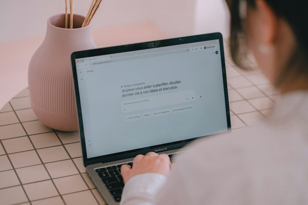 AI TubeStar Reviews: Features, Pricing, Pros, and Cons 28 Woman typing on a laptop with a vase nearby