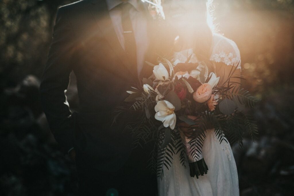 How to Plan a Luxury Wedding: The Complete Planning Guide 28 groom beside bride holding bouquet flowers