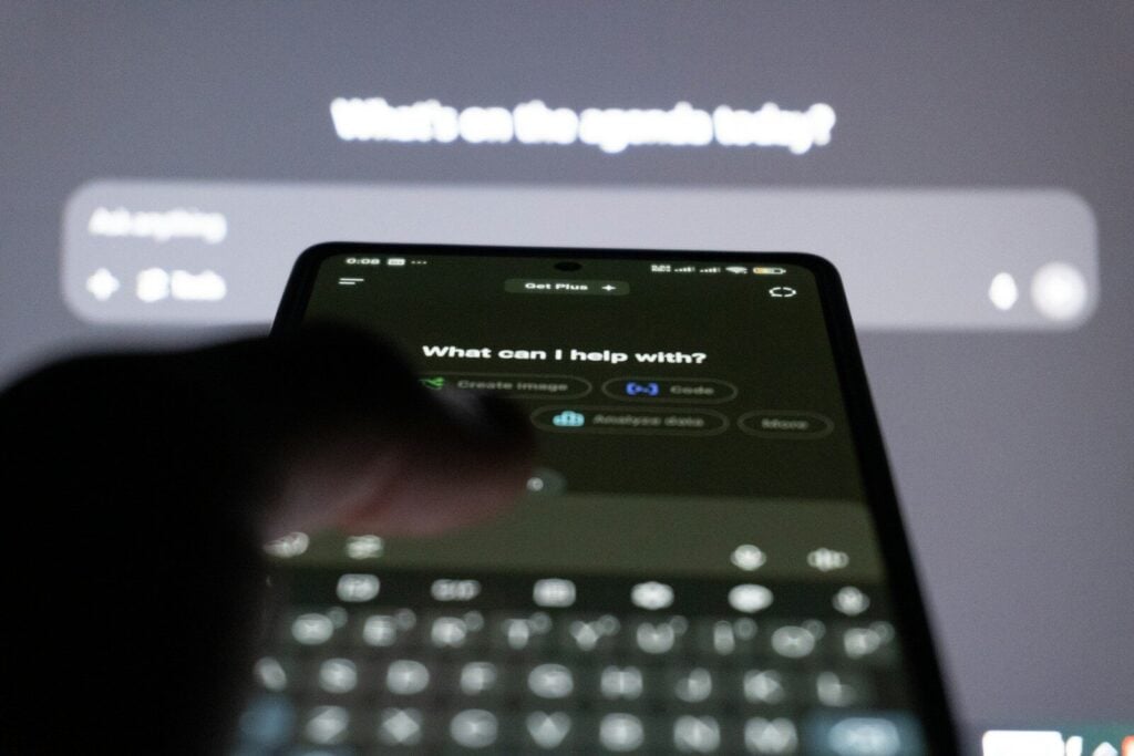 AI TubeStar Reviews: Features, Pricing, Pros, and Cons 27 Person typing on smartphone with ai chatbot on screen.