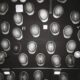 Many hard hats arranged on a dark wall.