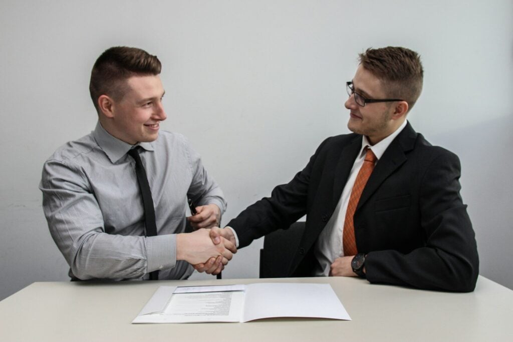 Business Formation Lawyer: Everything You Need to Know 27 two men facing each other while shake hands and smiling