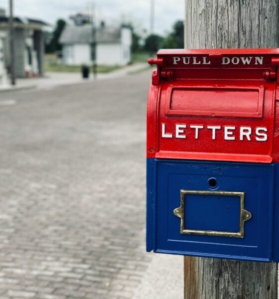 red mail box on brown wooden post