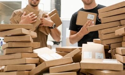 a couple of men standing next to a pile of boxes