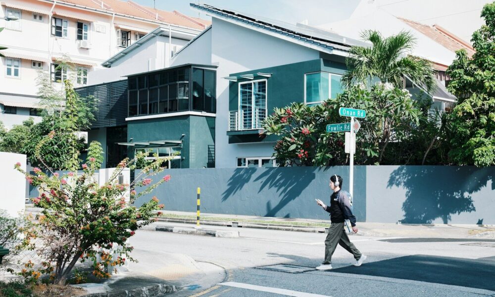 Person crossing street in front of modern house