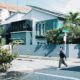Person crossing street in front of modern house